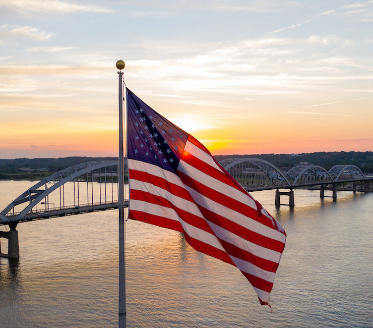 Drone shot of an american flag flying above the river